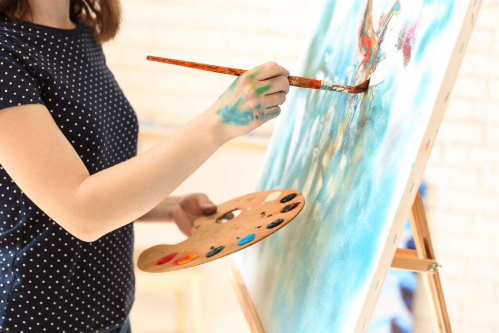 Female artist painting picture in workshop